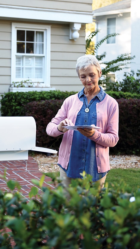 Woman at mailbox wearing HomeSafe